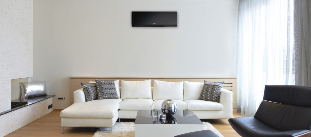 Living room with black ductless unit and white couch.